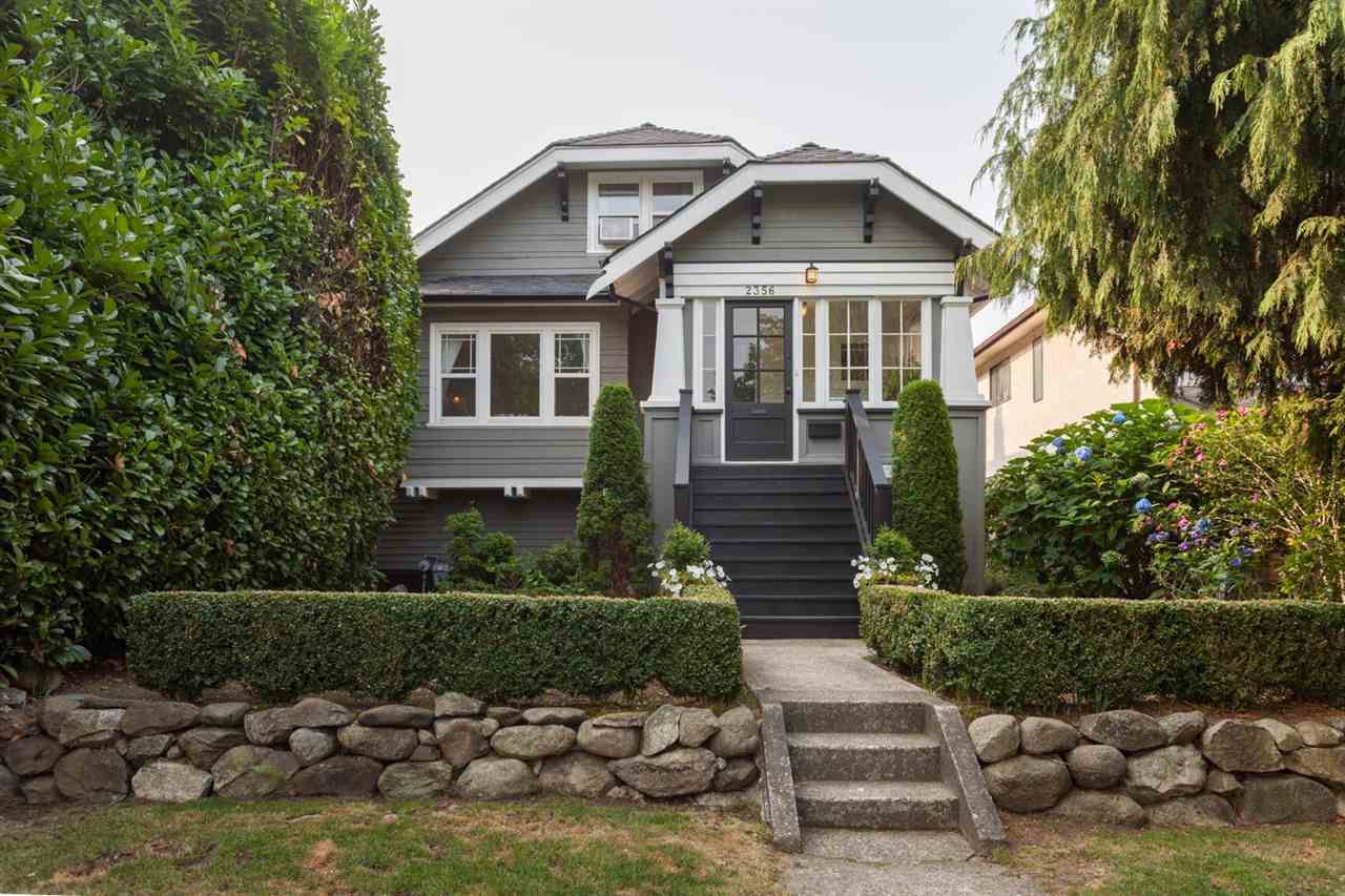 2356 Grant Street after renovation — repainted grey facade with new porch columns, clipped hedges and stone retaining wall