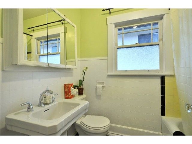 Bathroom before renovation — yellow walls, original tile and wall-hung basin