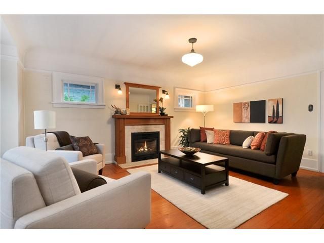 Living room before renovation — oak fireplace surround with mirror and neutral furnishings
