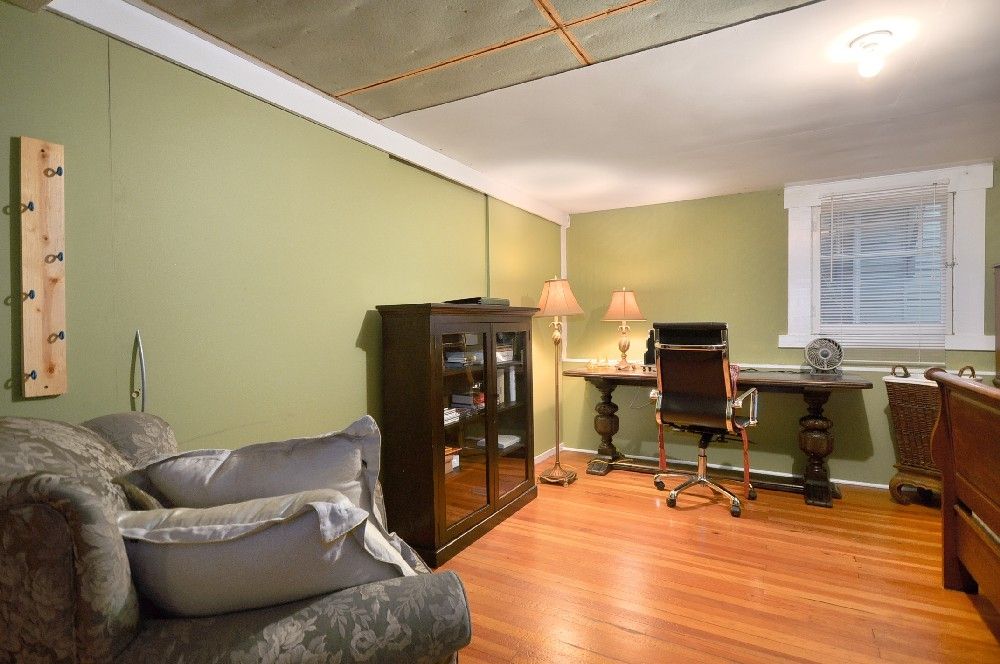 Sitting room before renovation — green walls, dropped ceiling and dark cabinetry